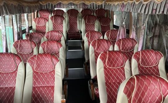 Có nhiều chiếc ghế màu đỏ dưới nền màu đen, phía trên là trần xe khách thuê xe Hà Nội đi Lào Cai